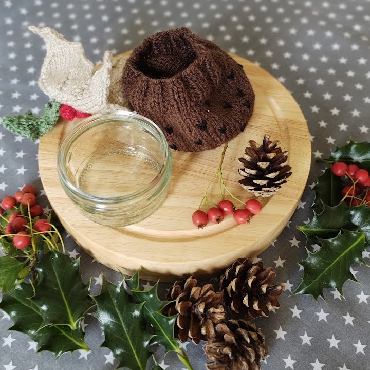 the handknit christmas pudding wrap is shown next to the empty ramekin